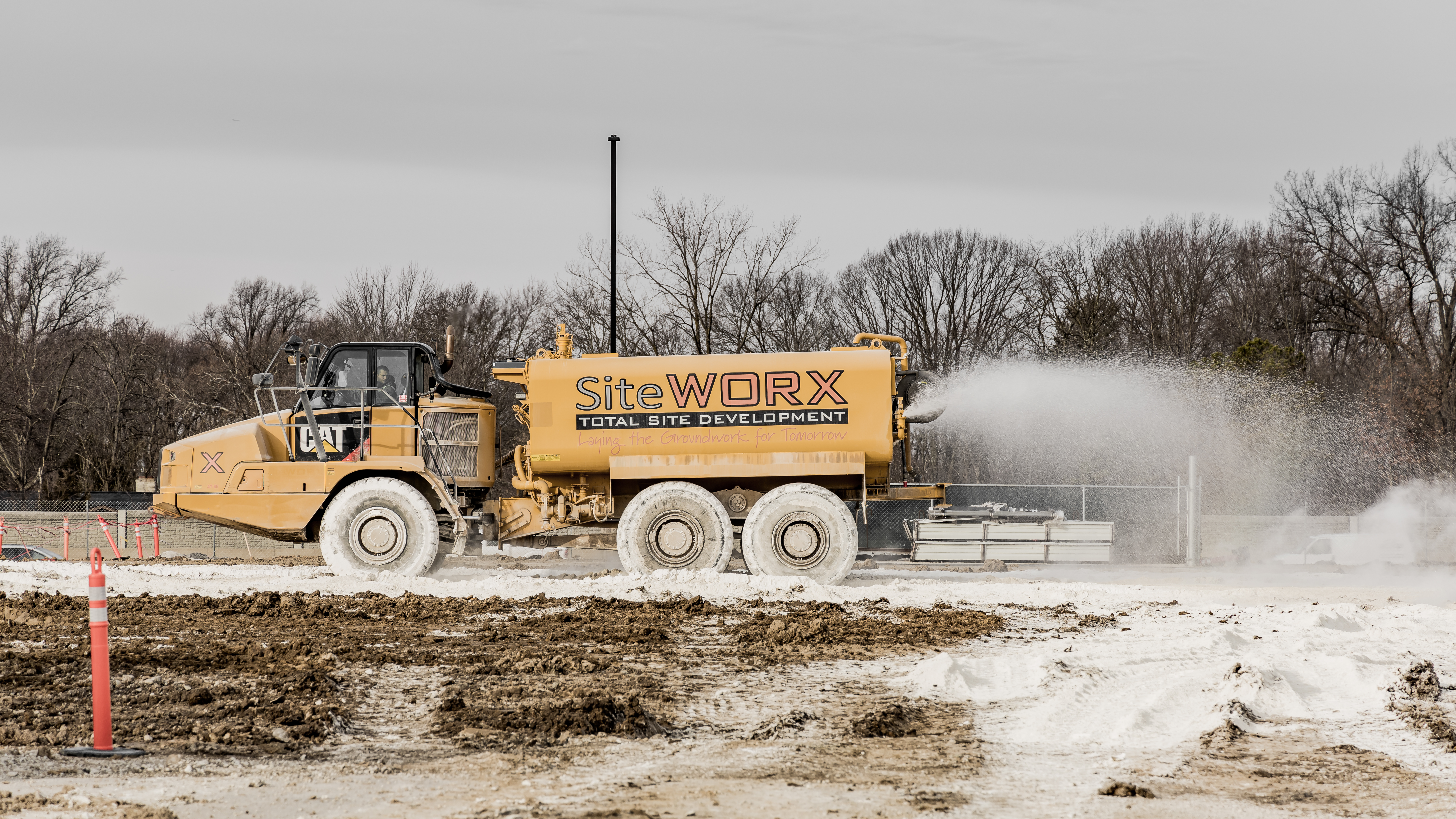 A piece of construction equipment spraying a substance on the ground